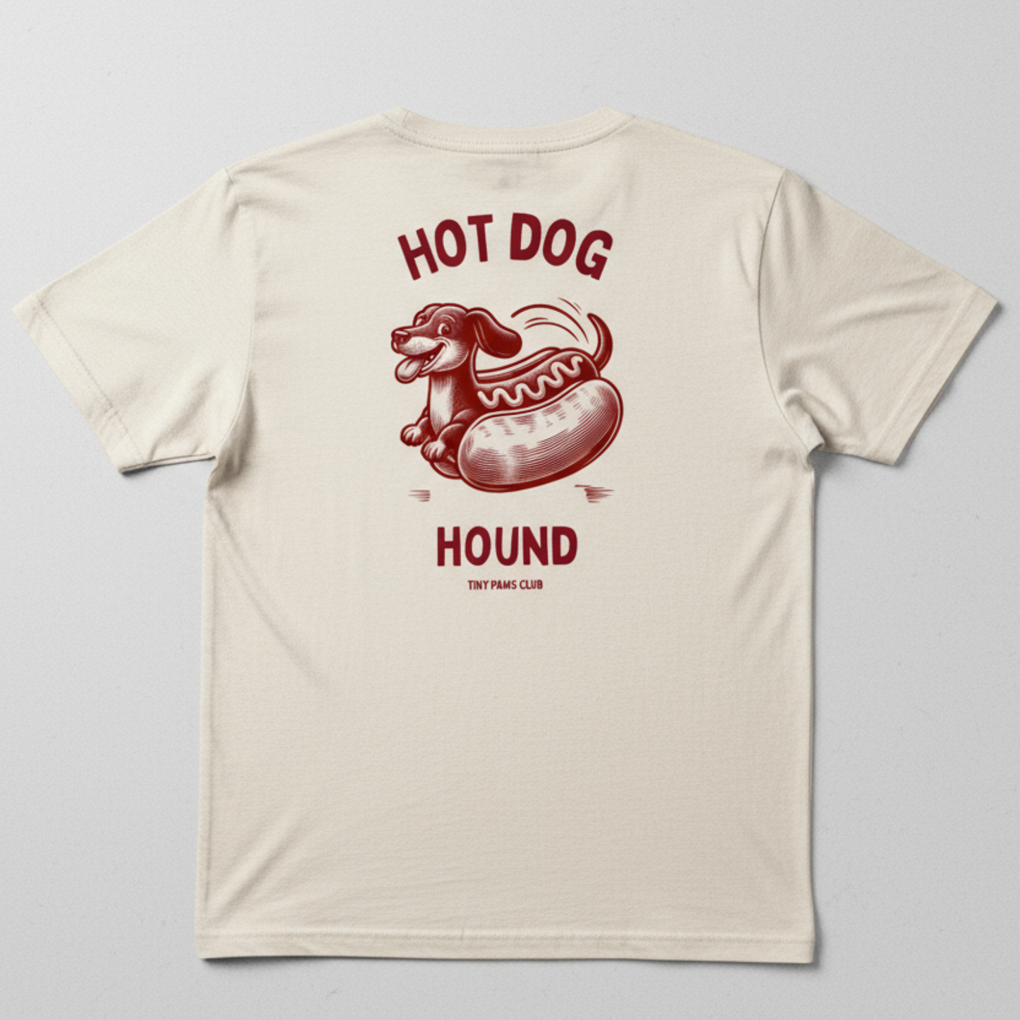 Beige t-shirt with a red hot dog graphic and text on a gray background