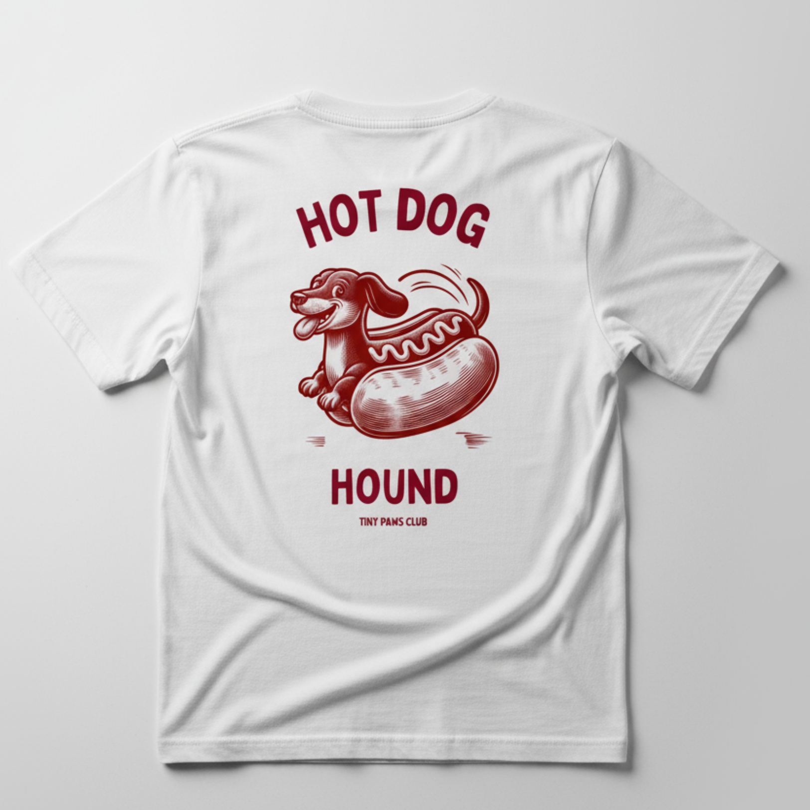 White t-shirt with red hot dog graphic and text on a light gray background dachshund shirt